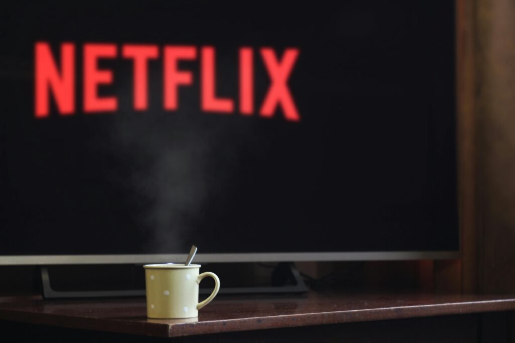 pexels-photo-2726370-2726370 A steaming mug on a table in front of a TV displaying Netflix, creating a cozy indoor atmosphere.
