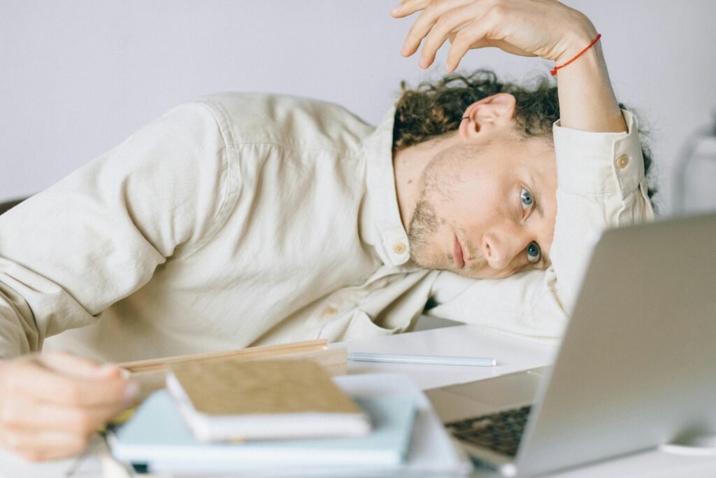 pexels-photo-6837648-6837648-1 A tired Caucasian man at a desk, showing signs of exhaustion and stress, exemplifying workplace burnout.