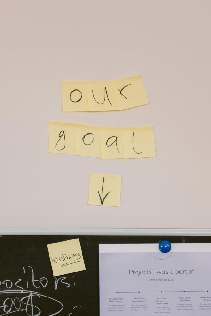 pexels-photo-6913222-6913222 Sticky notes on wall with 'Our Goal' text for office motivation.