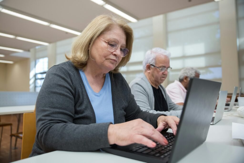 pexels-photo-7983577-7983577 Elderly individuals participating in a computer class to enhance digital skills.