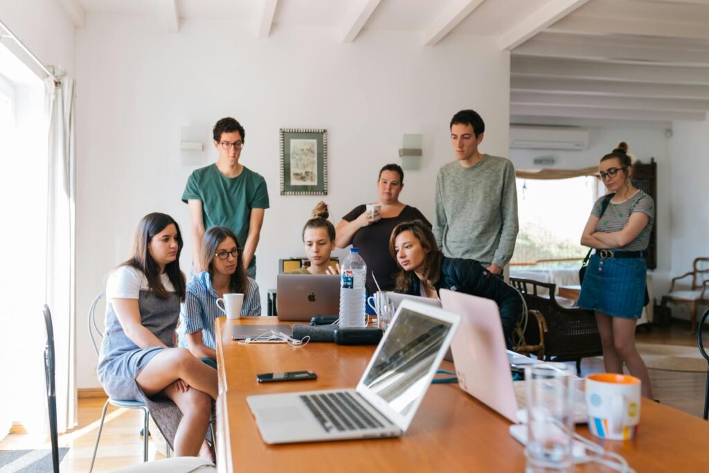 pexels-photo-1595385-1595385-1 Group of young professionals engaged in a collaborative meeting in a modern office setting.