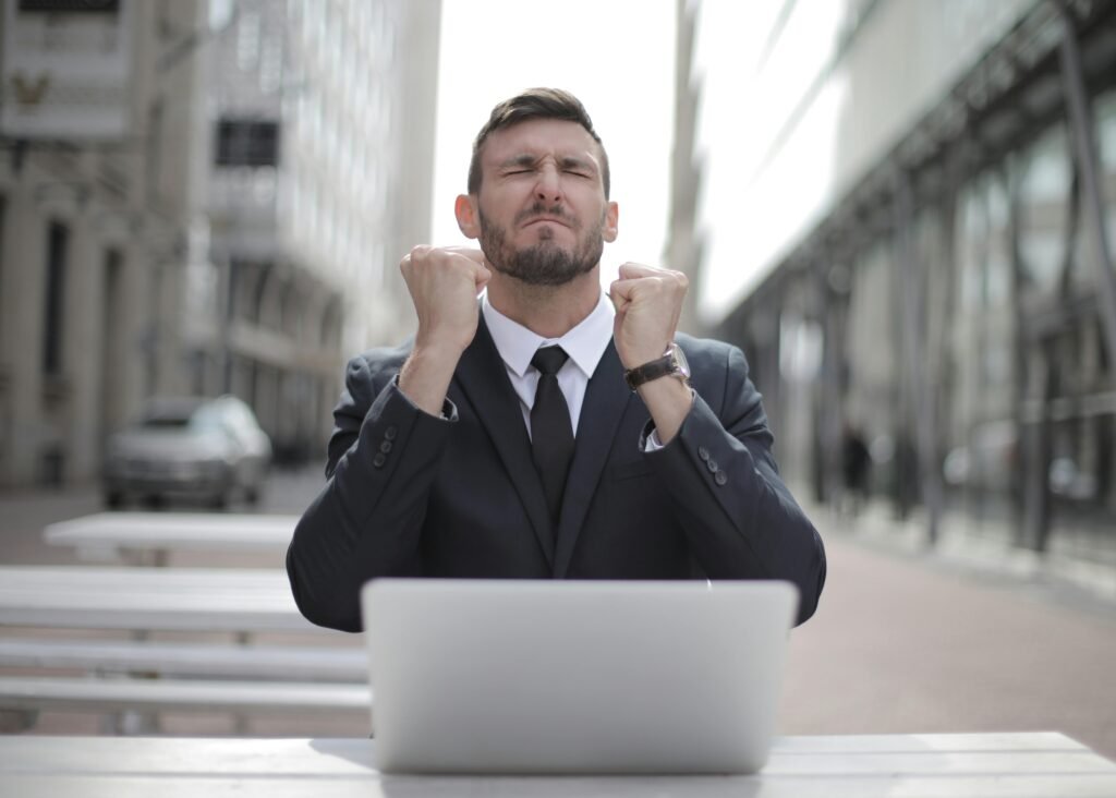 pexels-photo-3778966-3778966 Confident businessman in Budapest celebrates success with a fist pump, reflecting a professional achievement.