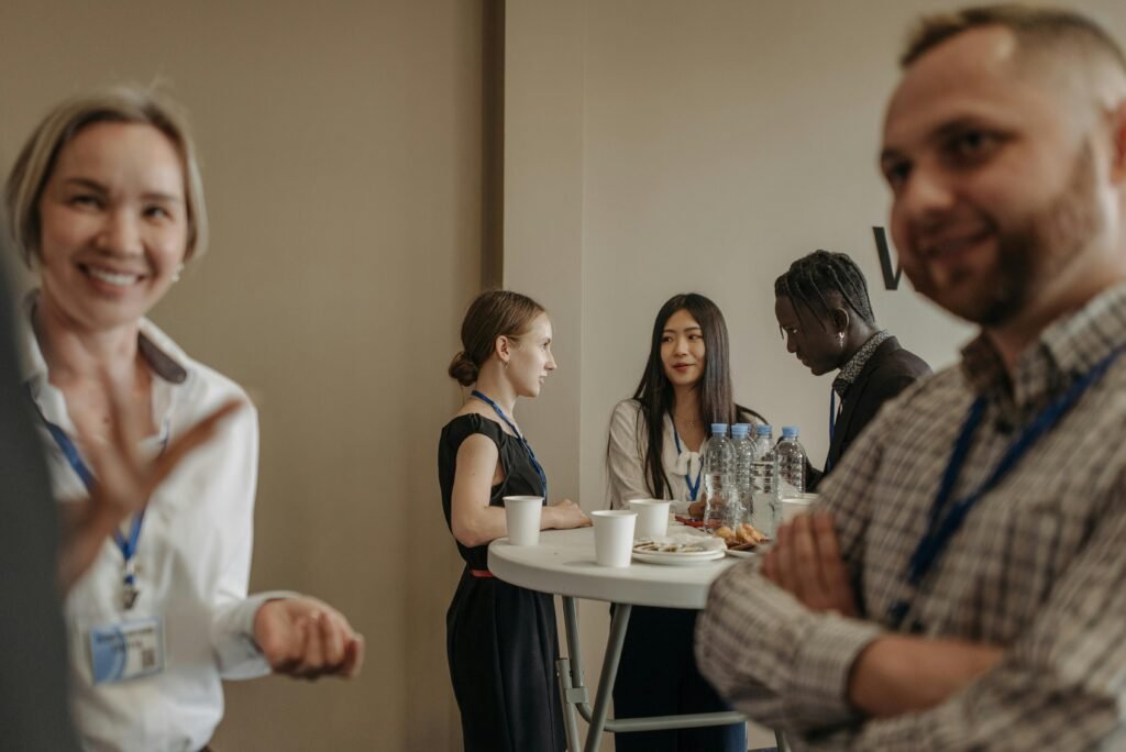 pexels-photo-8761648-8761648 A diverse group of adults networking during a business conference break with refreshments.